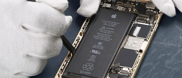 A technician wearing white gloves carefully works on replacing the internal lithium-ion battery of a gold iPhone, highlighting the expert battery replacement services provided by C&C Cell Phone & Computer Repair in the St. Louis area.